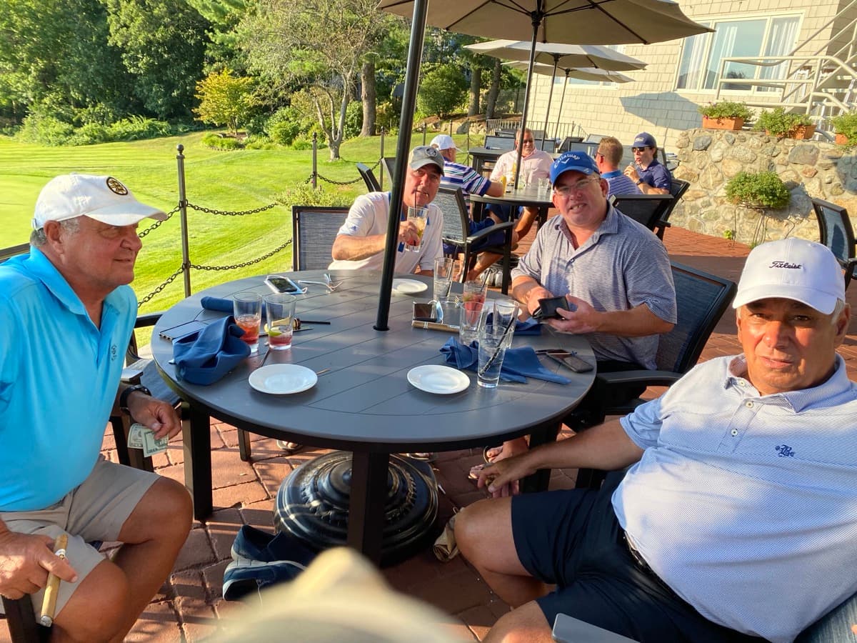 Members relaxing on the patio with golf course views